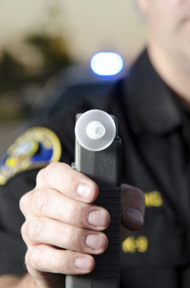 Police officer holding breathalyzer