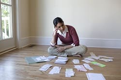 Woman looking at bills and receipts on floor